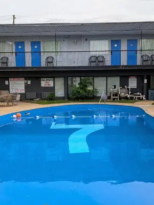 a large blue swimming pool in front of a building at 7 Nights Stay in Niagara Falls