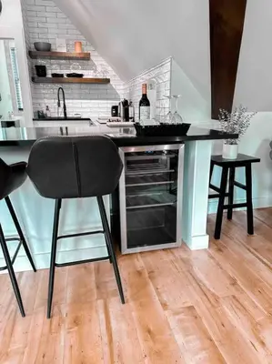 a kitchen with a counter with two stools and a counter top at Etherington Suites in Elora