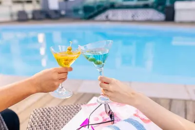 two people holding up wine glasses in front of a swimming pool at Hyatt Regency Toronto in Toronto
