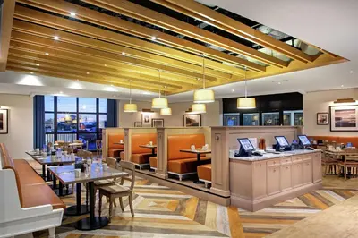 a dining room with tables and chairs and a restaurant at Doubletree by Hilton Toronto Airport, ON in Toronto