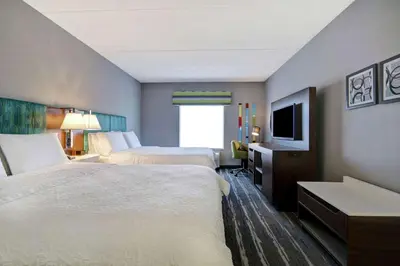 a hotel room with two beds and a television at Hampton Inn & Suites Guelph in Guelph