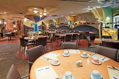 a dining room with wooden tables and chairs at Holiday Inn Niagara Falls-By the Falls by IHG in Niagara Falls
