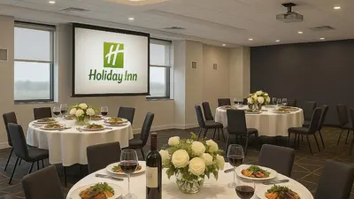 a conference room with tables and chairs and a screen at Holiday Inn & Suites Mississauga West - Meadowvale by IHG in Mississauga