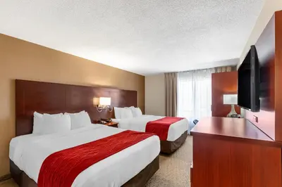 a hotel room with two beds and a flat screen tv at Comfort Inn Airport West in Mississauga