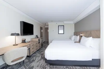 a hotel room with a large bed and a tv at Sandman Signature Toronto Airport Hotel in Toronto
