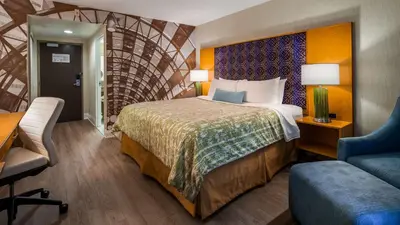 a hotel room with a bed and a desk and a chair at Best Western Premier Toronto Airport Carlingview Hotel in Toronto