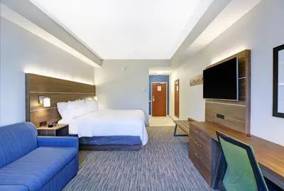 a hotel room with a bed and a flat screen tv at Holiday Inn Express Whitby Oshawa by IHG in Whitby