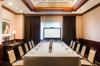 a conference room with a long table and a projection screen at The Yorkville Royal Sonesta Hotel Toronto in Toronto