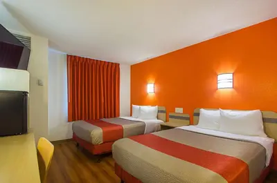 a hotel room with two beds and a television at Motel 6-Whitby, ON - Toronto East in Whitby