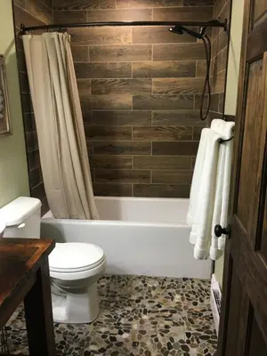 a bathroom with a toilet and a bath tub with at The Village Suites in Wellington