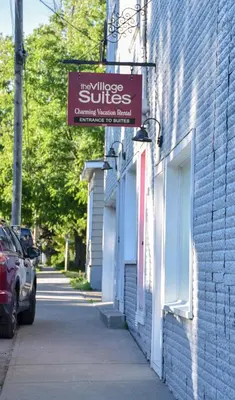 a sign for the village suites on the side of a building at The Village Suites in Wellington