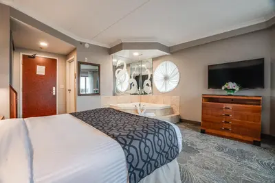 a hotel room with a bed and a tub and a television at Monte Carlo Inn Barrie - Newly Renovated in Barrie