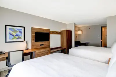 a hotel room with two beds and a desk with a television at Holiday Inn Express Hotel & Suites Toronto - Markham by IHG in Richmond Hill