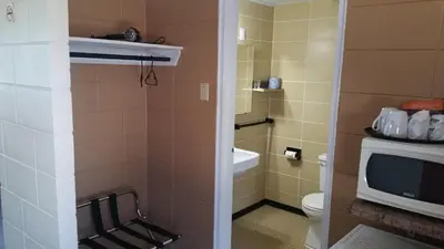 a bathroom with a toilet and a television at Riverview Motel in Dunnville