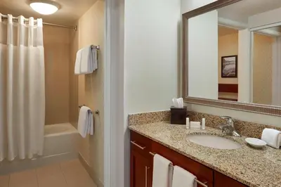 a bathroom with a sink and a mirror and a tub at Residence Inn by Marriott Gravenhurst Muskoka Wharf in Gravenhurst