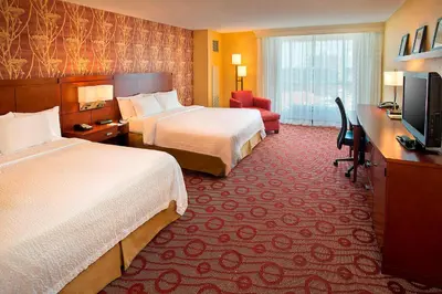 a hotel room with two beds and a flat screen tv at Courtyard by Marriott Niagara Falls in Niagara Falls