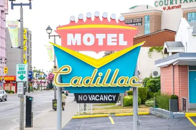 a sign for a motel called cadiliana on a city street at Cadillac Motel Niagara in Niagara Falls