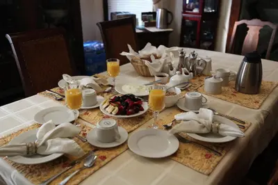 a table with white plates and glasses of orange juice at Ambiance By The Falls B&B in Niagara Falls