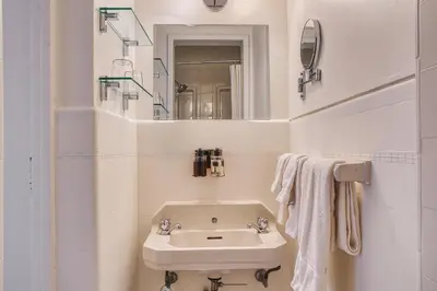 a white bathroom with a sink and a mirror at The Windsor Hotel by Hoco Hotels Collection in Stratford