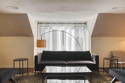 a living room with a black couch and a window at The Windsor Hotel by Hoco Hotels Collection in Stratford