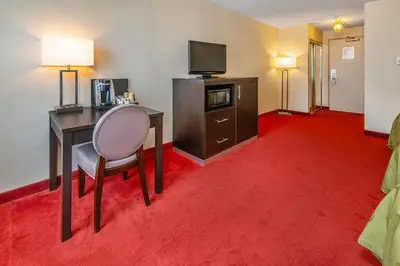 a hotel room with a desk and a television at Rodeway Inn Festival in Stratford