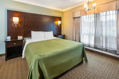 a hotel room with a large bed and windows at Rodeway Inn Festival in Stratford