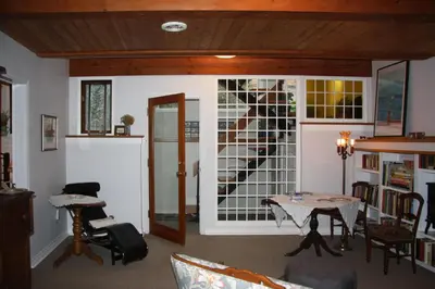 a living room with a table and a window at 2 Moon Cottage in Niagara on the Lake