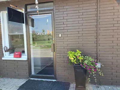 a door to a store with a potted plant next to it at Carriage Inn Motel in Peterborough