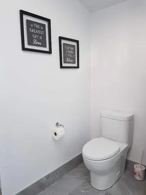 a bathroom with a toilet and a picture on the wall at Newton Villa in Brampton