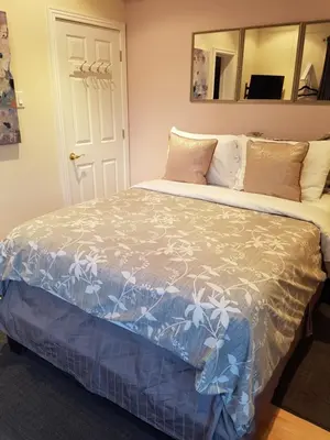 a bedroom with a large bed with a large mirror at Newton Villa in Brampton