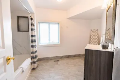a bathroom with a tub and a sink at Newton Villa in Brampton