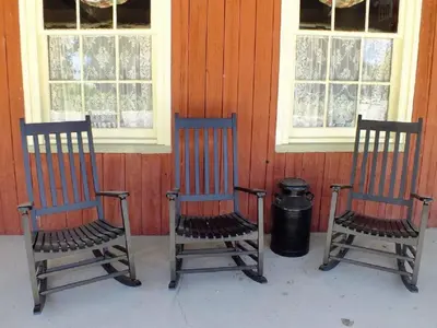 two chairs sitting on a porch in front of windows at The Chepstow Inn in Chepstow