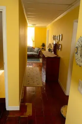 a hallway with yellow walls and a living room at The Chepstow Inn in Chepstow