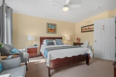 a bedroom with a bed and a living room at Charlottetown House in Niagara on the Lake