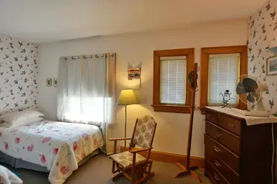 a bedroom with a bed and a chair and a dresser at 10th Avenue Guest House & Suites in Hanover