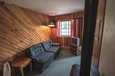 a living room with a couch and a tv at High Falls Bay Cottages, Camping & Waterpark in Bracebridge