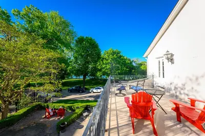 a balcony with red chairs and a view of a street at The Old Bank House in Niagara on the Lake
