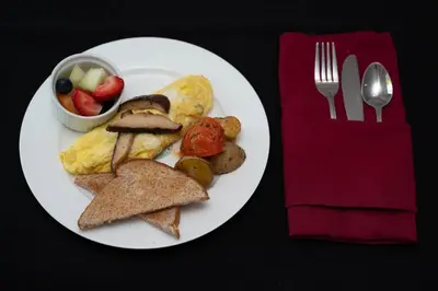 a plate of breakfast food with toast and a bowl of fruit at The Old Bank House in Niagara on the Lake