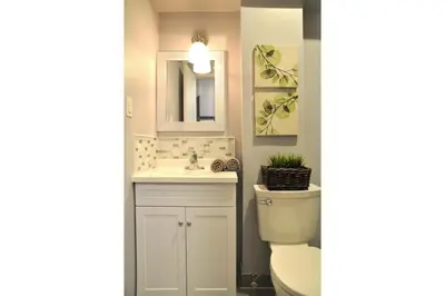 a bathroom with a toilet and a sink and a mirror at Dream Catcher Travel House in Toronto