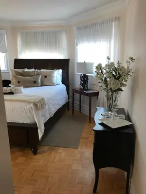 a bedroom with a bed and a vase of flowers on a table at Molly's Retreat B and B in Orangeville