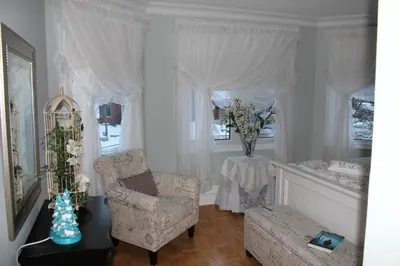 a living room with a chair and a table with flowers at Molly's Retreat B and B in Orangeville