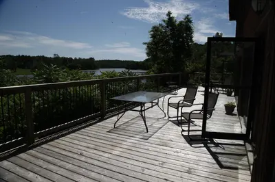 a wooden deck with a table and chairs on it at Benmiller Inn & Spa in Goderich
