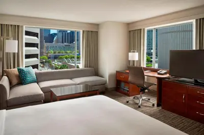 a hotel room with a couch and a desk with a computer at Marriott Downtown at CF Toronto Eaton Centre in Toronto