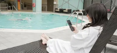 a woman sitting in a chair in front of a swimming pool at Toronto Airport Marriott Hotel in Toronto