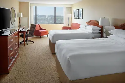 a hotel room with two beds and a desk at Toronto Airport Marriott Hotel in Toronto