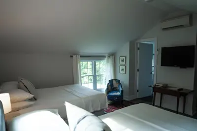 a bedroom with two beds and a flat screen tv at South Landing Inn in Niagara on the Lake