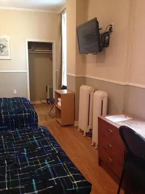 a bedroom with a bed and a tv on the wall at The Rex Hotel Jazz & Blues Bar in Toronto