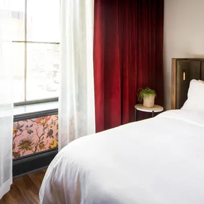 a bedroom with a white bed and a window at The Broadview Hotel in Toronto
