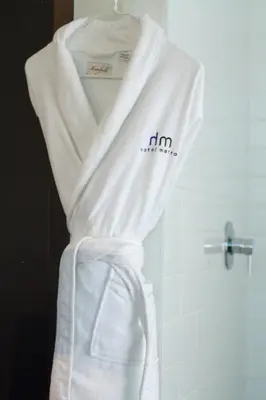 a white robe hanging in a bathroom next to a shower at Hotel Metro in London