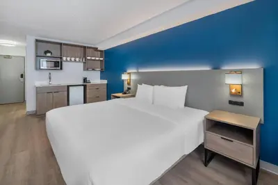 a bedroom with a large white bed and a blue wall at Comfort Inn in Belleville